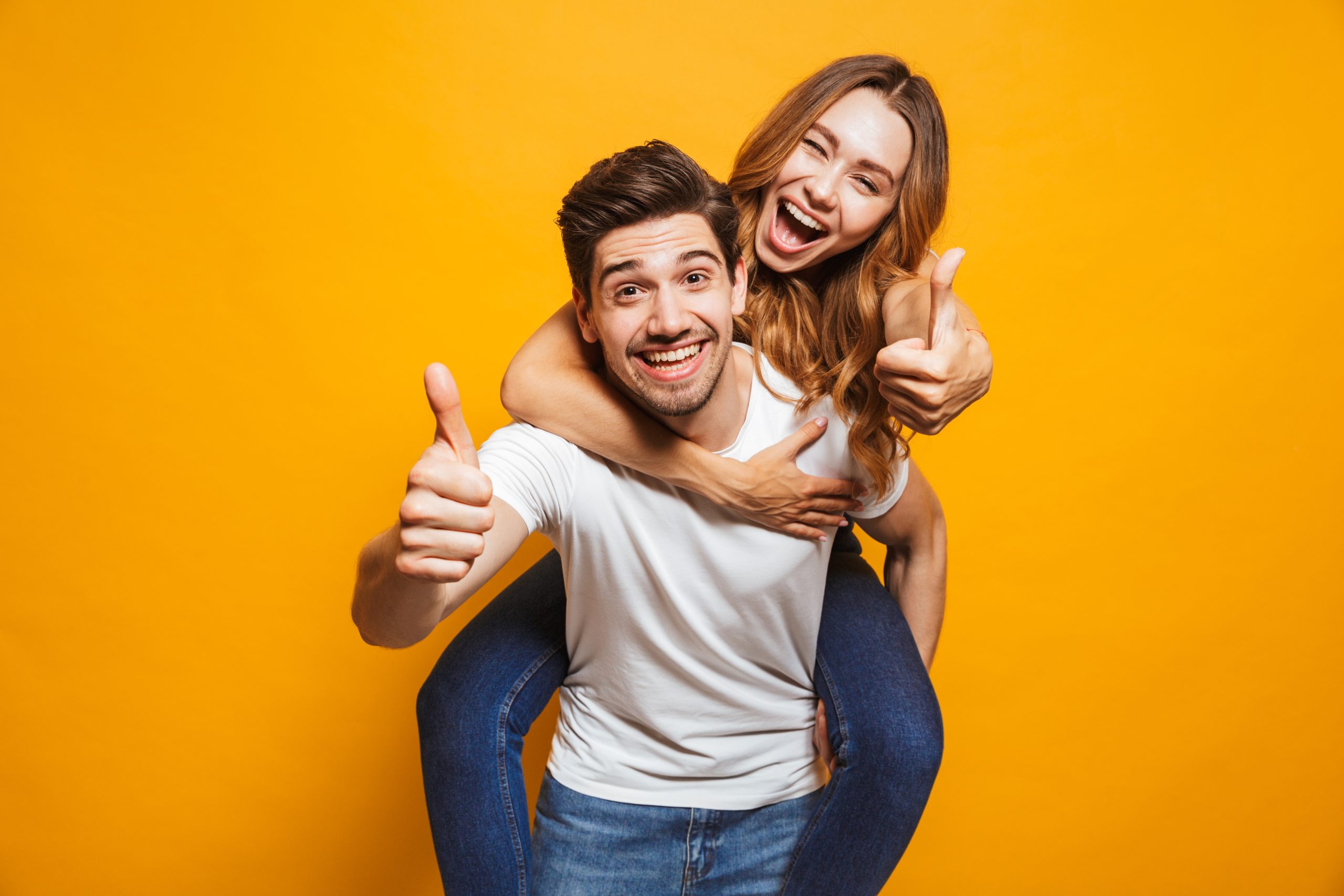 Image,Of,Joyous,Couple,Showing,Thumbs,Up,While,Man,Piggybacking