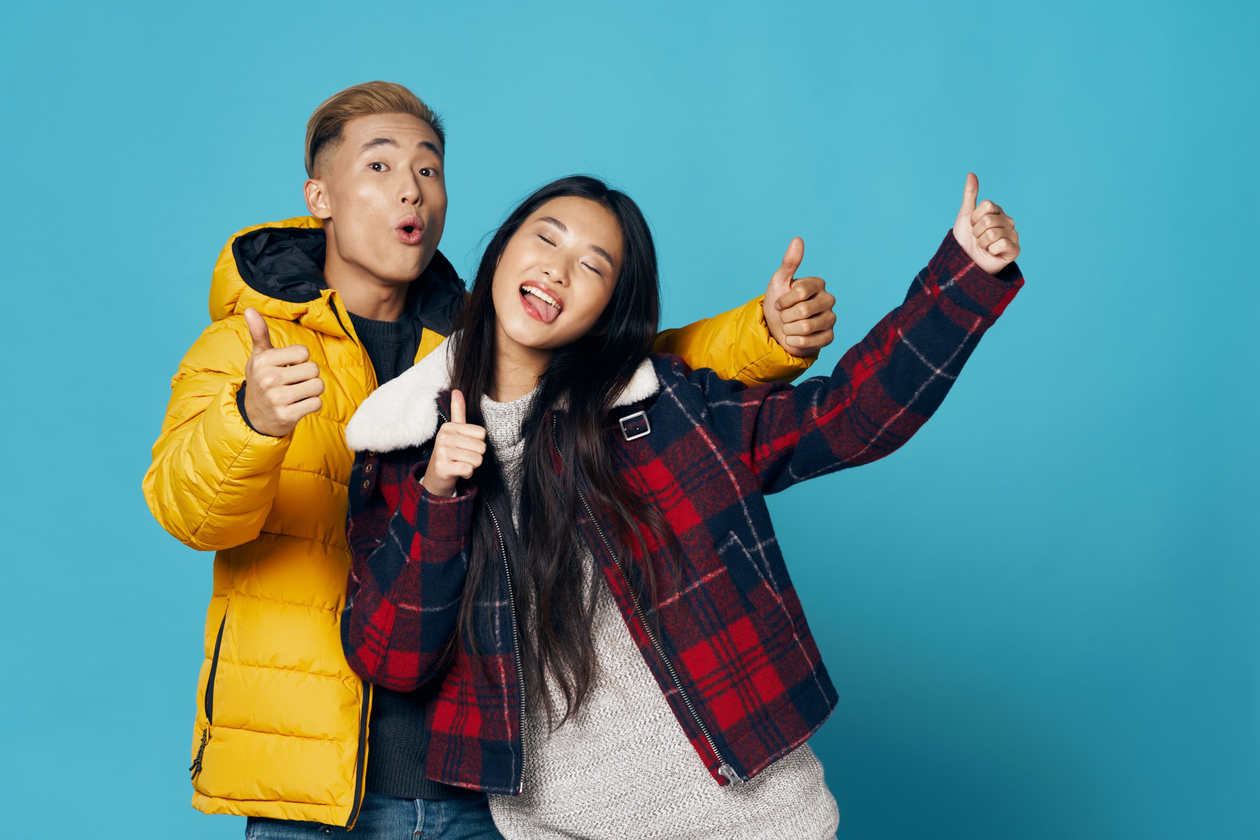 Happy,Young,People,In,Warm,Jackets,On,A,Blue,Background