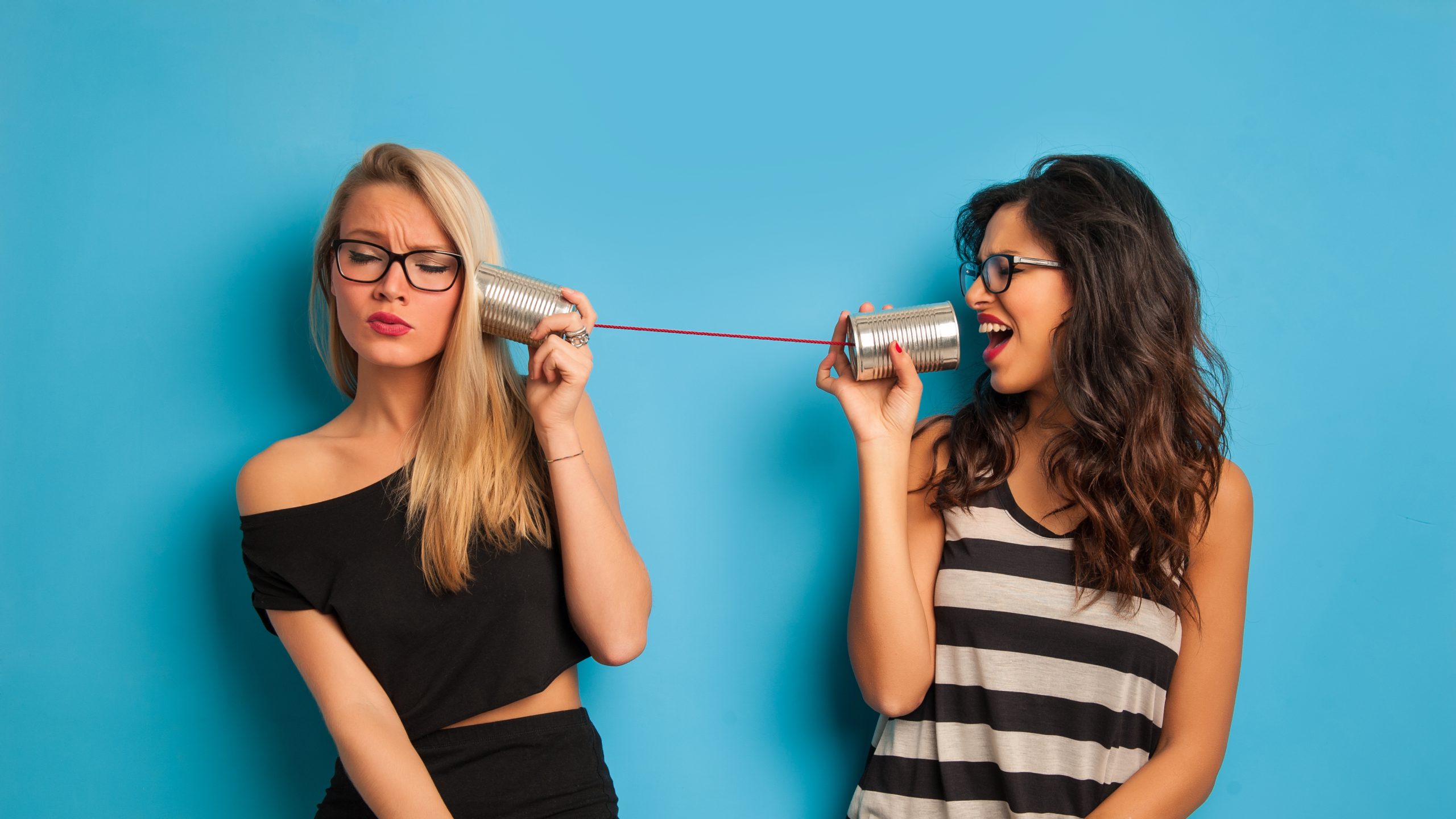 Blonde,And,Brunette,Women,Talking,With,Tin,Can,Telephone,Against