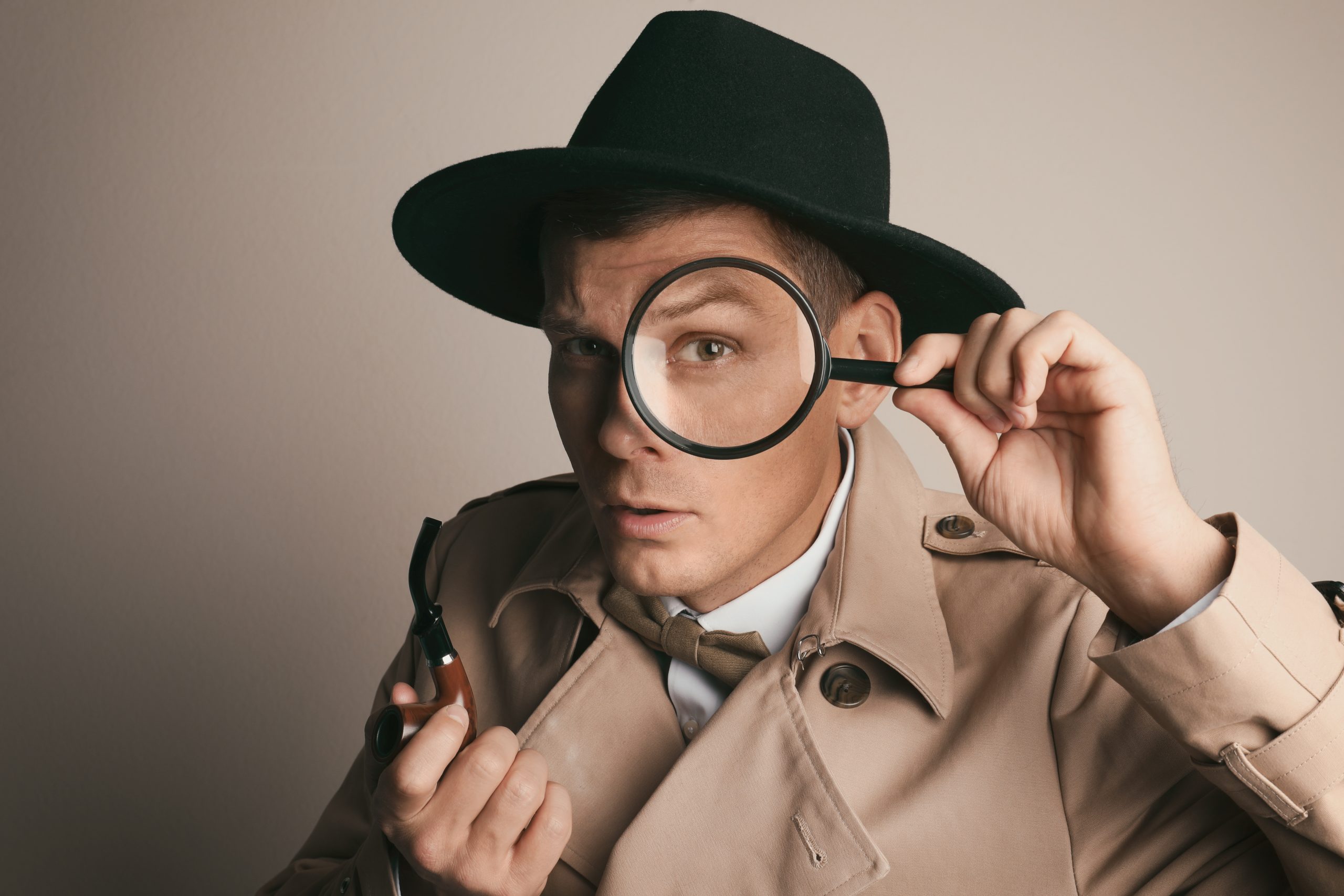 Male,Detective,With,Smoking,Pipe,Looking,Through,Magnifying,Glass,On